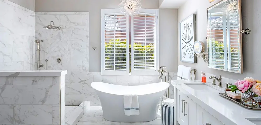 Luxury bathroom remodel with white marble walk-in shower, matching floor tile, freestanding tub, and white double vanity.