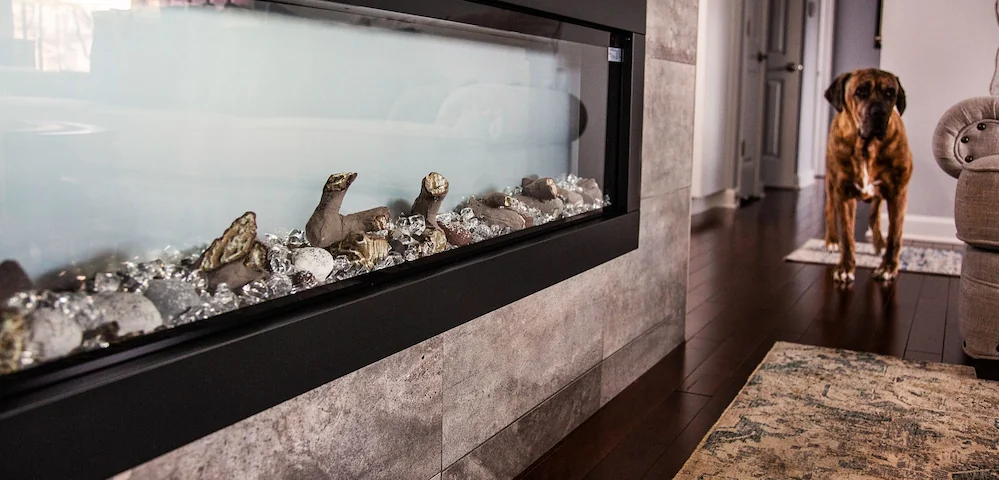 Open-concept living room and kitchen with medium-toned hardwood floors, white kitchen cabinets, and a sunlit breakfast nook.