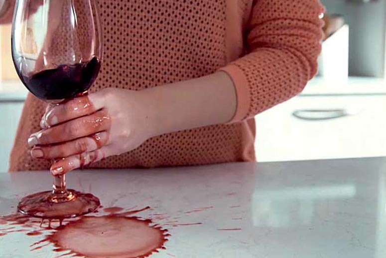 Quartz countertop with red wine spilled on it.