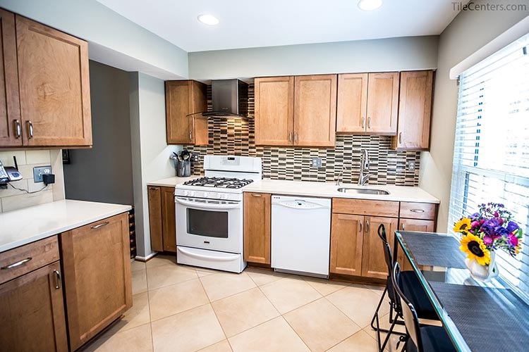 Functional kitchen with natural color cabinets and recessed lights