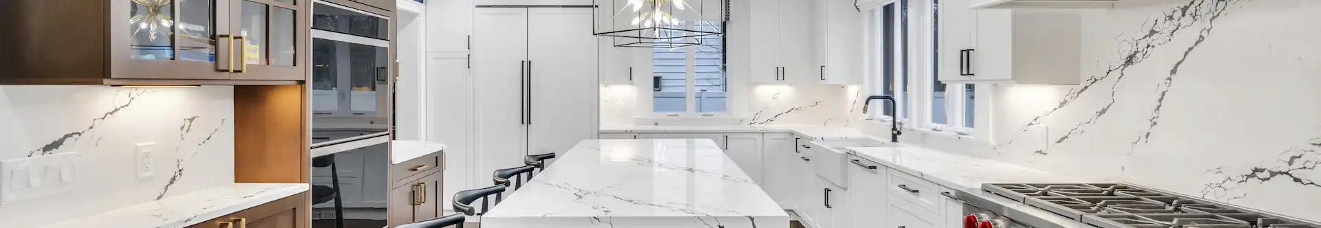 Modern kitchen with white quartz countertops, blue island cabinetry, hardwood floors.