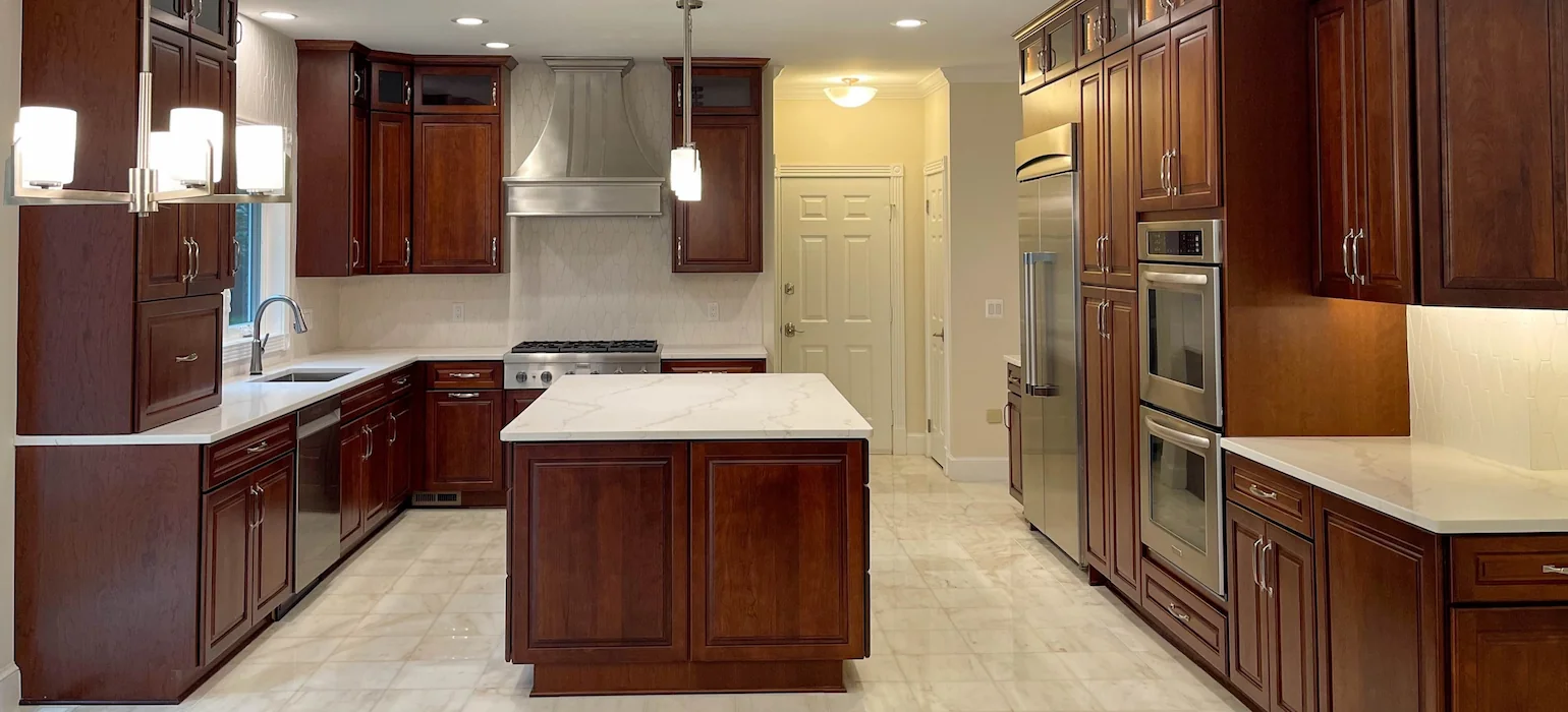 Traditional Potomac, MD kitchen remodel with cherry wood cabinets, white marble island, and large-format porcelain floor tile.